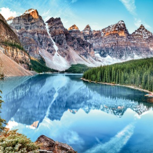 A photo of mountains overlooking a pristine alpine lake